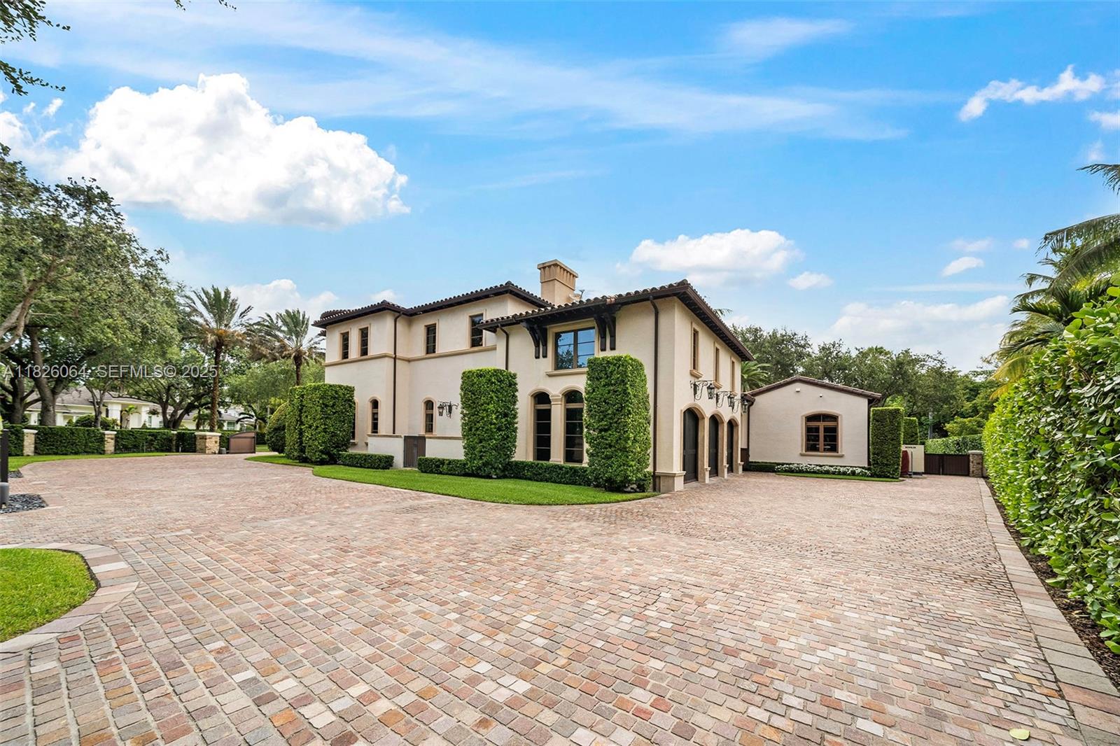 10101 Southwest 60th Court Pinecrest, FL 33156 - Photo 12 of 98 a front view of a house with a yard and garage