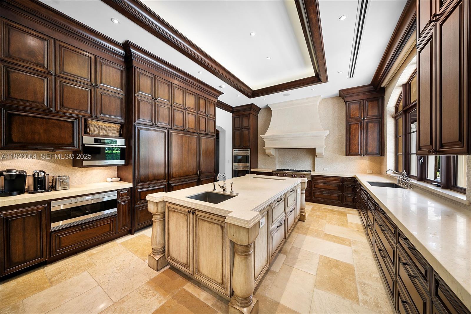 10101 Southwest 60th Court Pinecrest, FL 33156 - Photo 27 of 98 a kitchen with stainless steel appliances granite countertop a sink and a stove