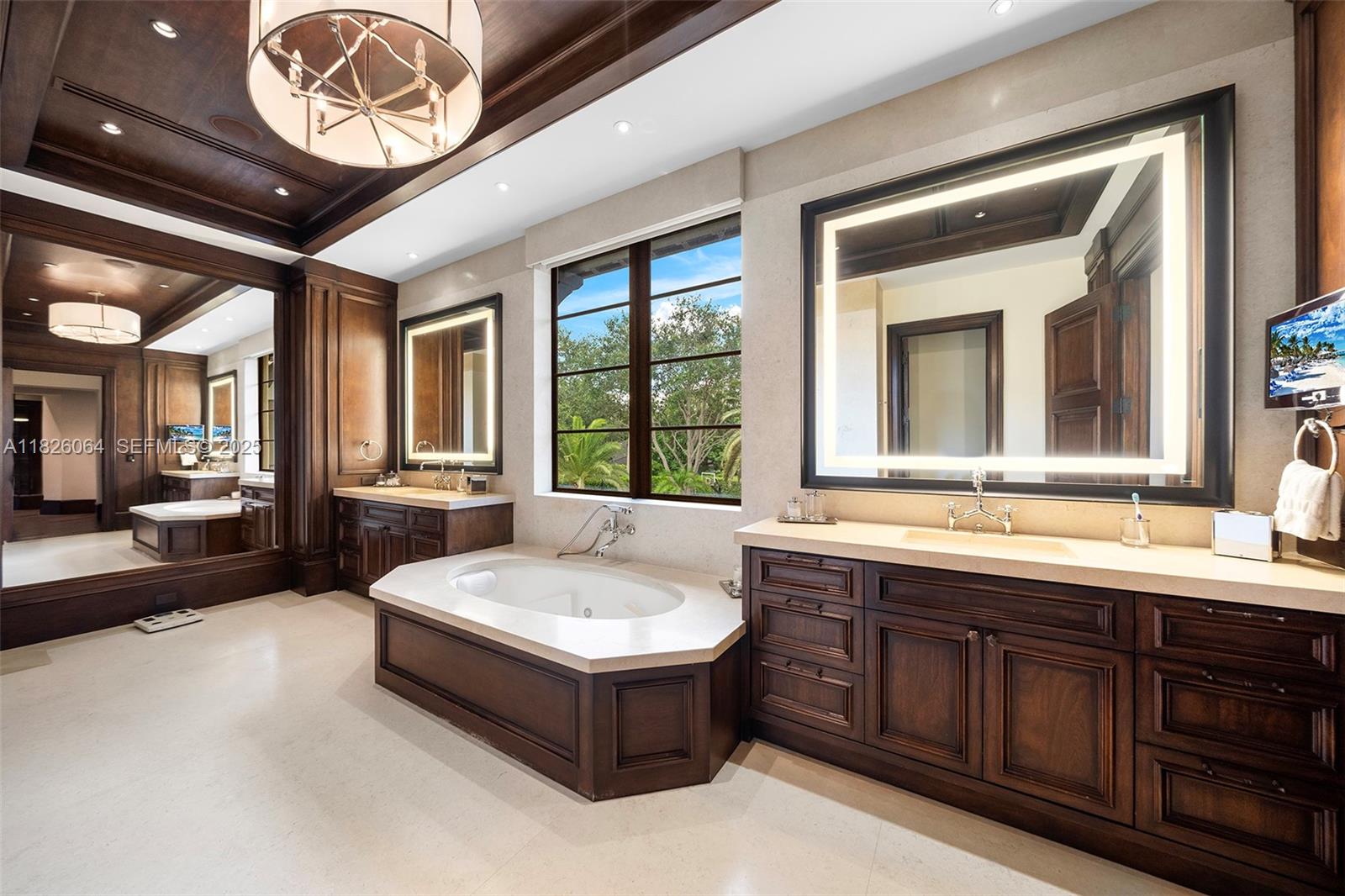 10101 Southwest 60th Court Pinecrest, FL 33156 - Photo 43 of 98 a spacious bathroom with a tub a double vanity sink and a large mirror