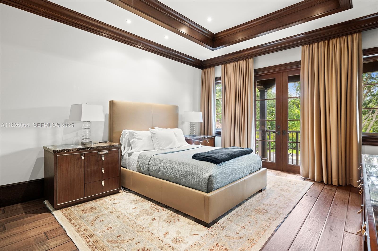10101 Southwest 60th Court Pinecrest, FL 33156 - Photo 48 of 98 a spacious bedroom with a bed and glass door