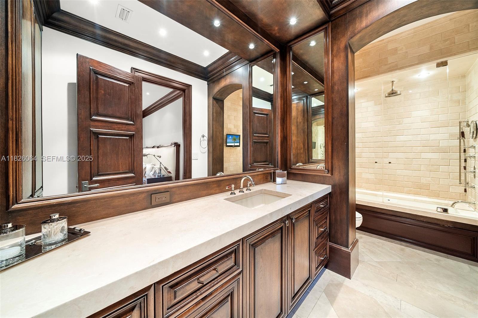 10101 Southwest 60th Court Pinecrest, FL 33156 - Photo 49 of 98 a bathroom with a sink and a large mirror
