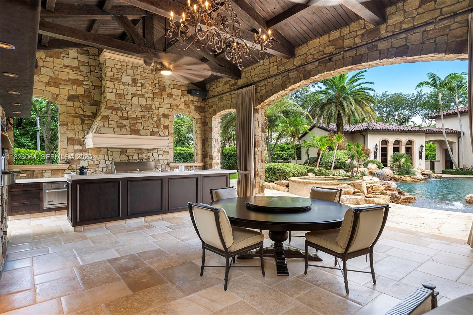 10101 Southwest 60th Court Pinecrest, FL 33156 - Photo 68 of 98 a view of a patio with table and chairs potted plants and large tree