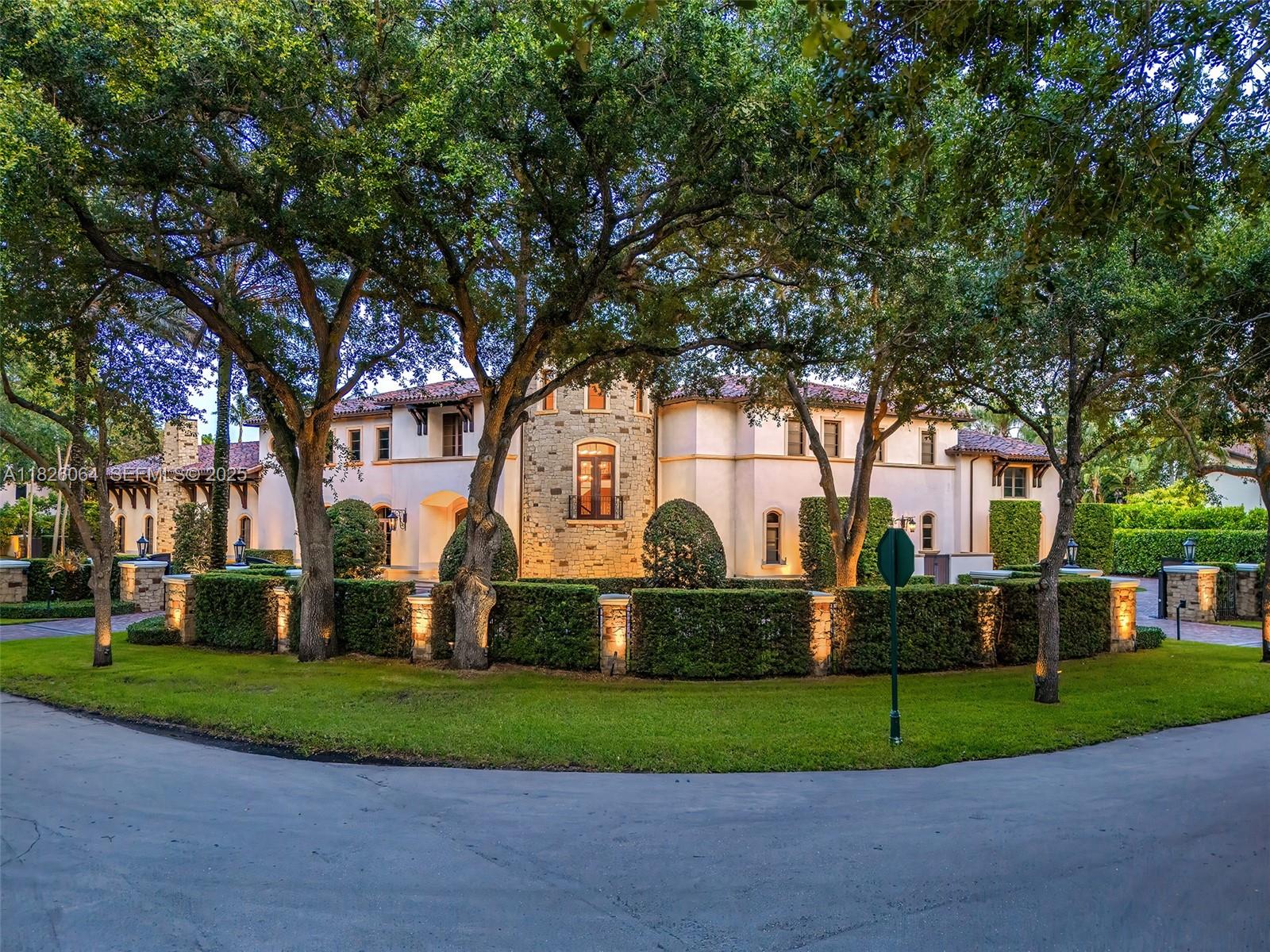 10101 Southwest 60th Court Pinecrest, FL 33156 - Photo 7 of 98 a front view of a house with a garden and trees