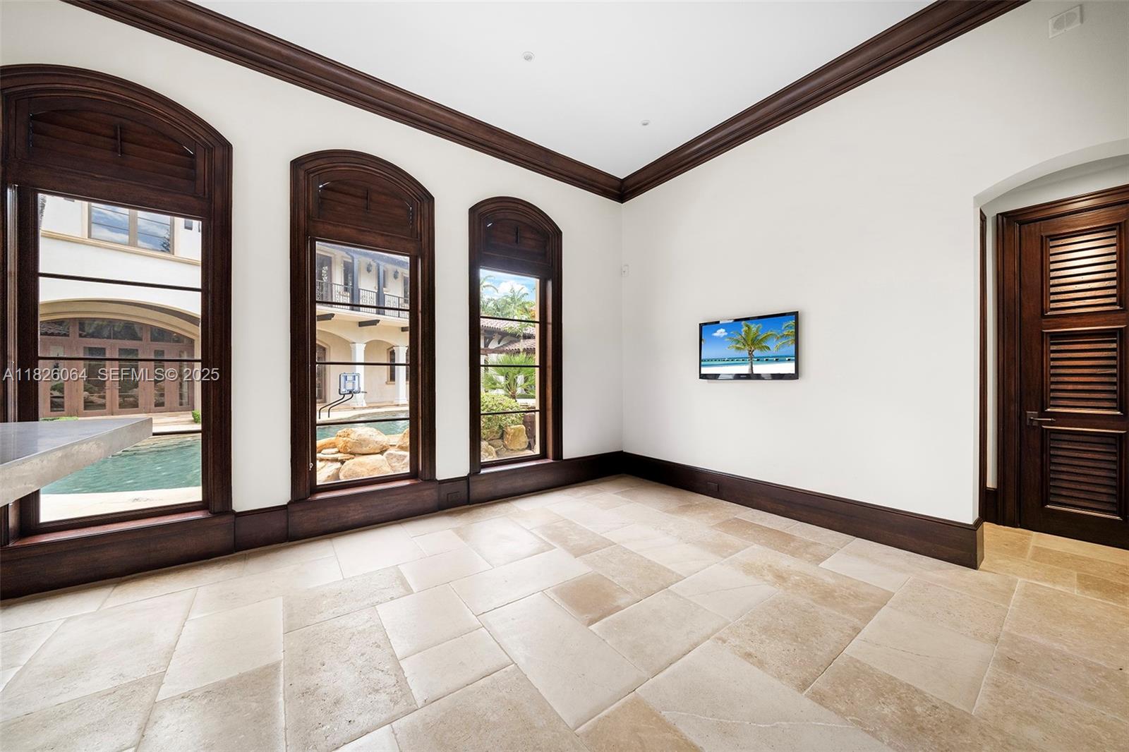 10101 Southwest 60th Court Pinecrest, FL 33156 - Photo 81 of 98 a view of an empty room with a fireplace and a large window
