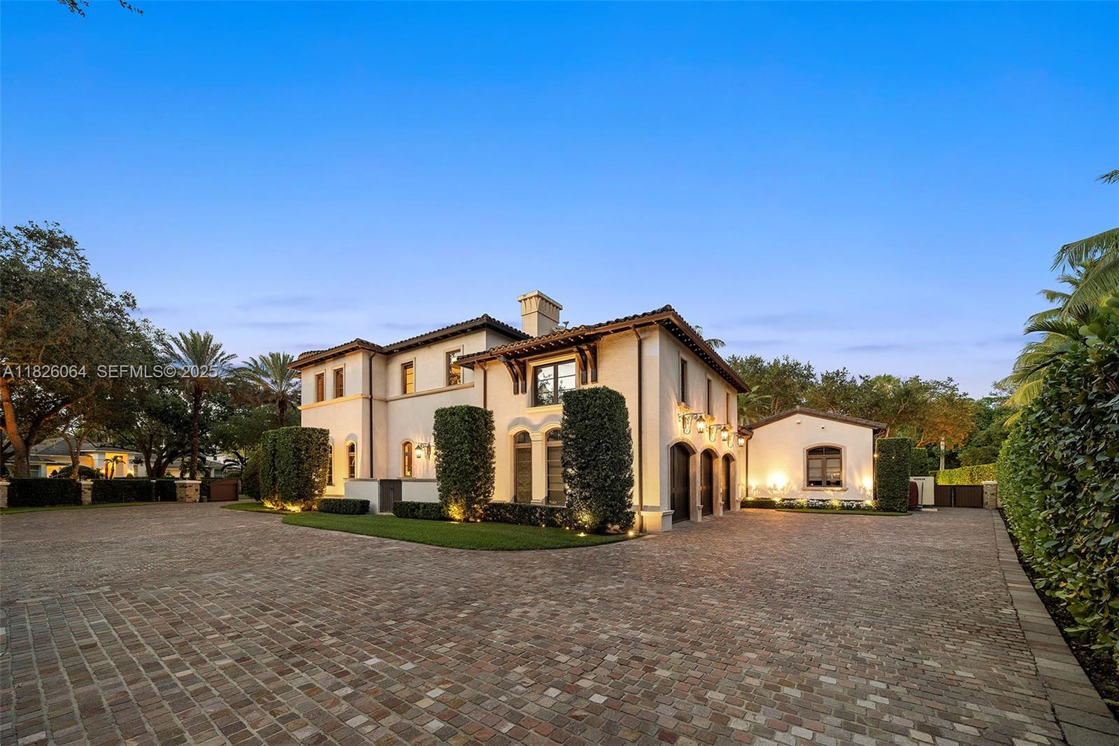 10101 Southwest 60th Court Pinecrest, FL 33156 - Photo 9 of 98 a view of a white house with a big yard and large trees