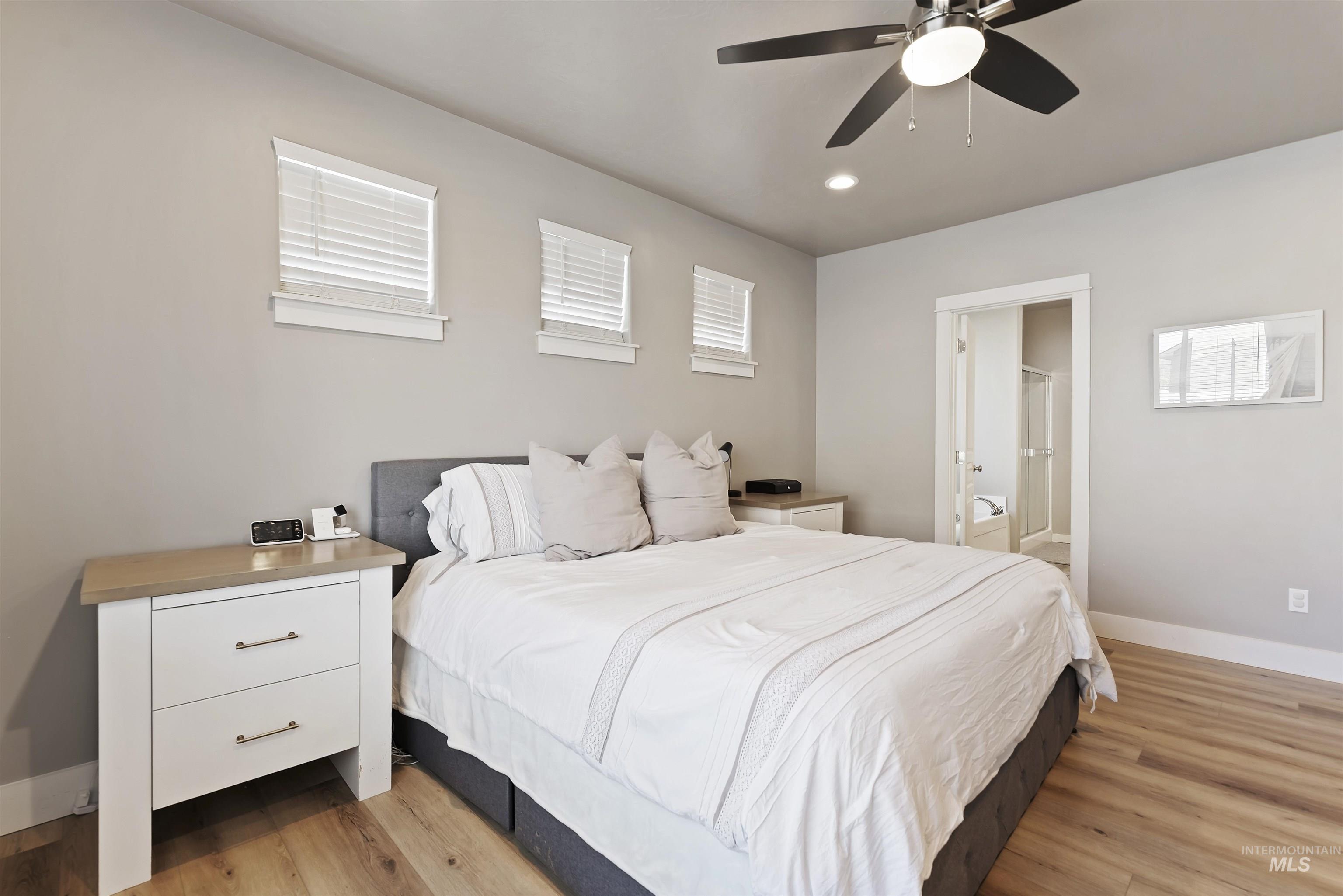 654 Diamond Lake Street Middleton, ID 83644 - Photo 15 of 36 Bedroom featuring light wood-style floors, connected bathroom, a ceiling fan, and recessed lighting
