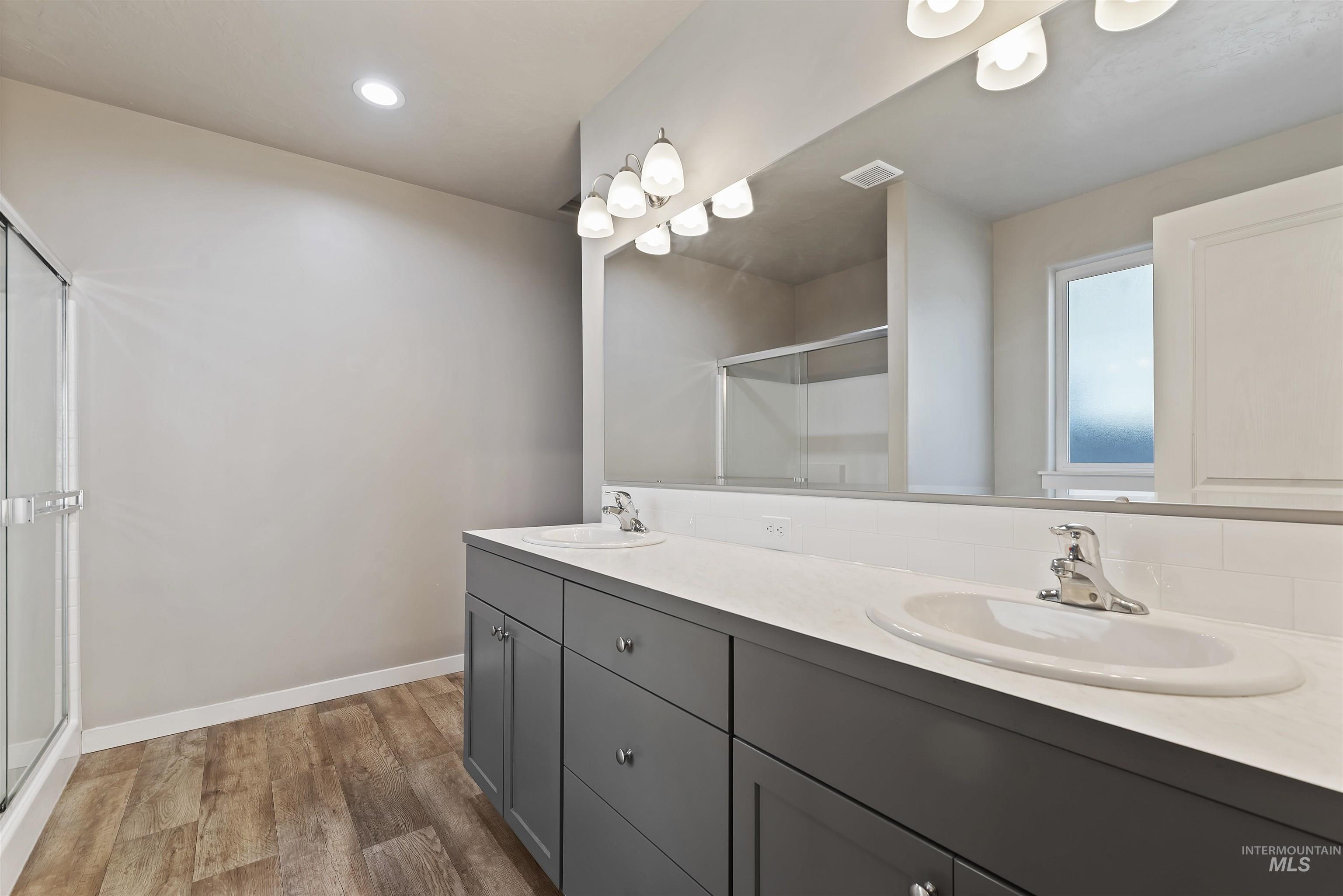 654 Diamond Lake Street Middleton, ID 83644 - Photo 17 of 36 Full bathroom featuring double vanity, light wood-type flooring, a stall shower, and recessed lighting