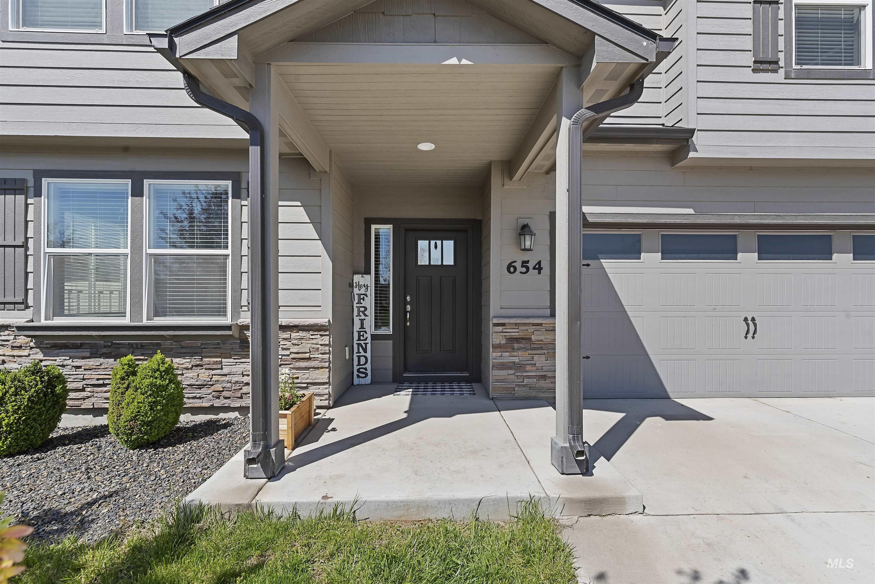 654 Diamond Lake Street Middleton, ID 83644 - Photo 2 of 36 Doorway to property featuring stone siding, a garage, covered porch, and concrete driveway
