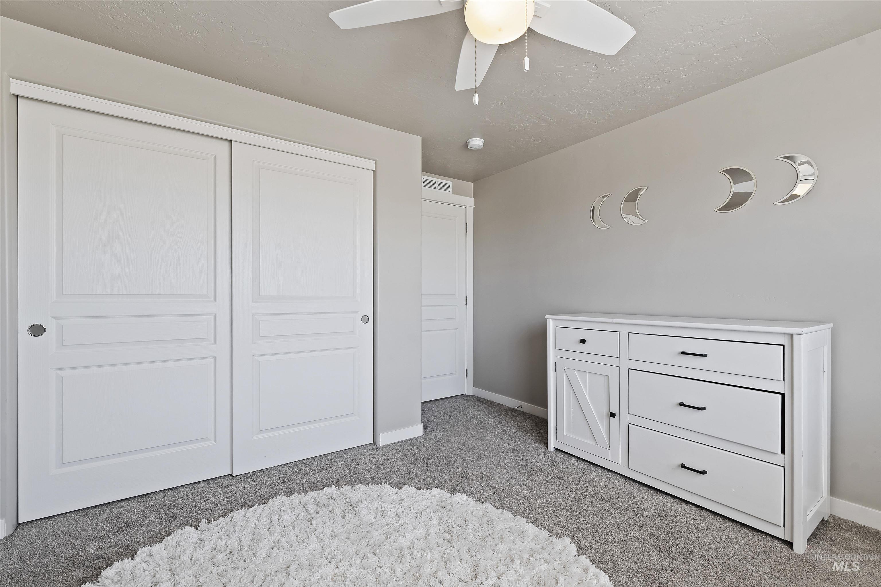 654 Diamond Lake Street Middleton, ID 83644 - Photo 26 of 36 Bedroom with light carpet, a closet, and a ceiling fan