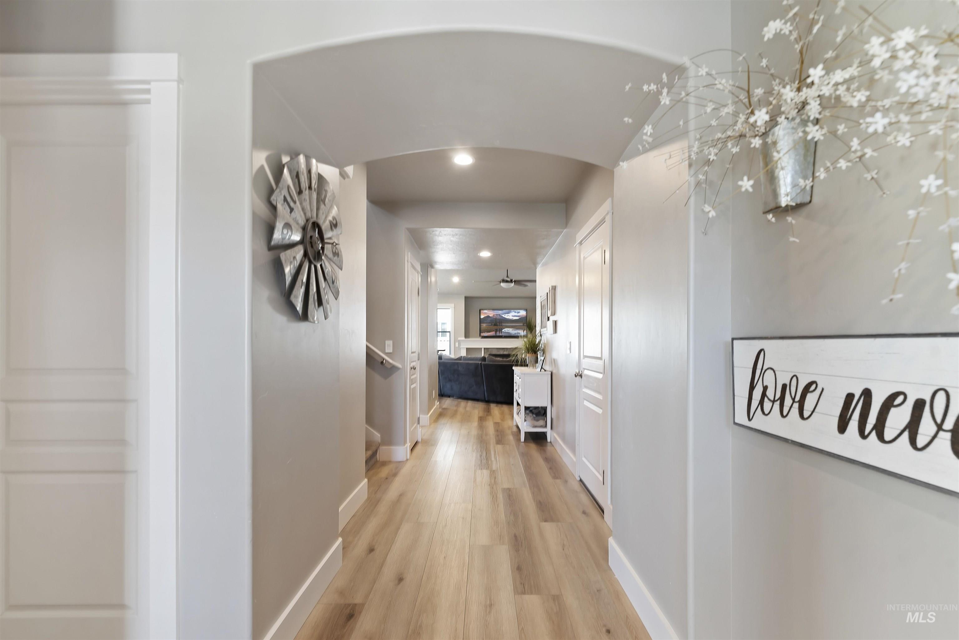654 Diamond Lake Street Middleton, ID 83644 - Photo 4 of 36 Corridor with light wood finished floors, recessed lighting, and arched walkways