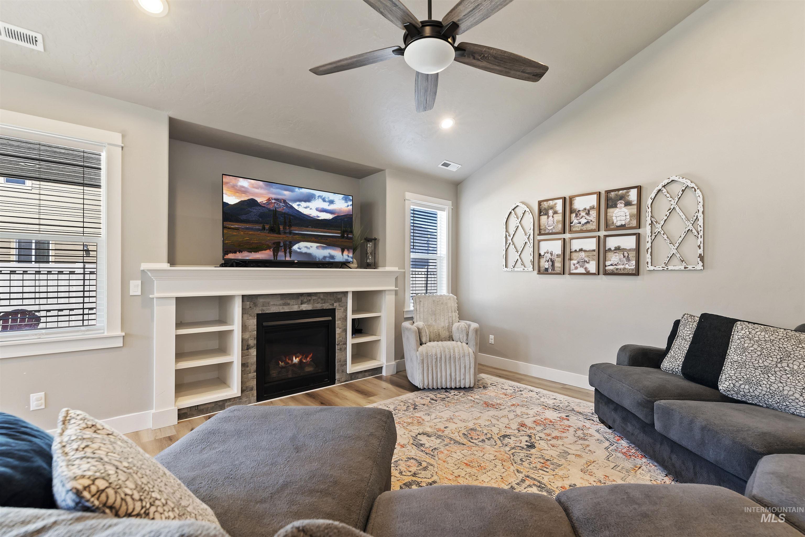 654 Diamond Lake Street Middleton, ID 83644 - Photo 6 of 36 Living area featuring wood finished floors, lofted ceiling, a ceiling fan, recessed lighting, and a lit fireplace