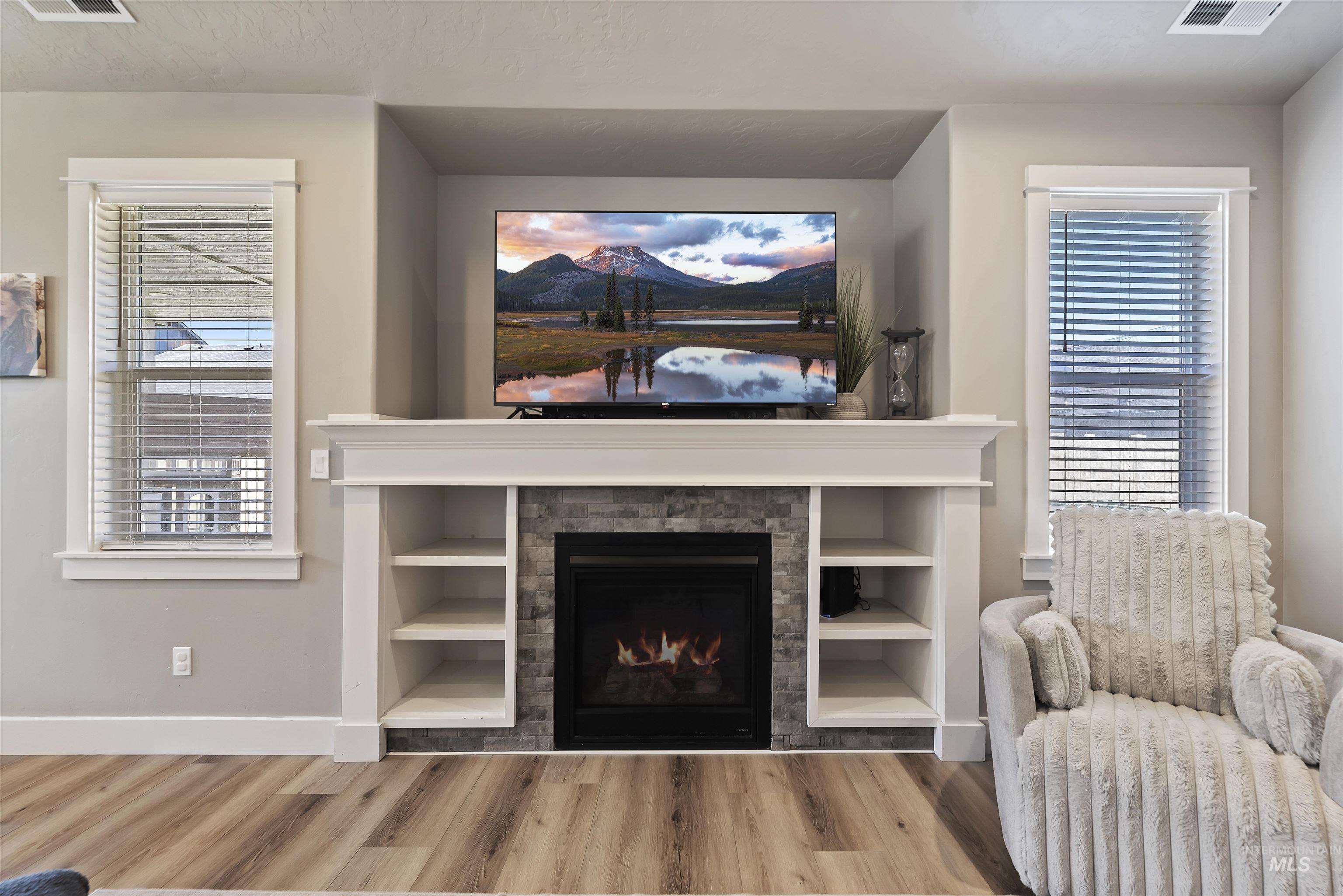 654 Diamond Lake Street Middleton, ID 83644 - Photo 7 of 36 Living room featuring light wood finished floors and a lit fireplace