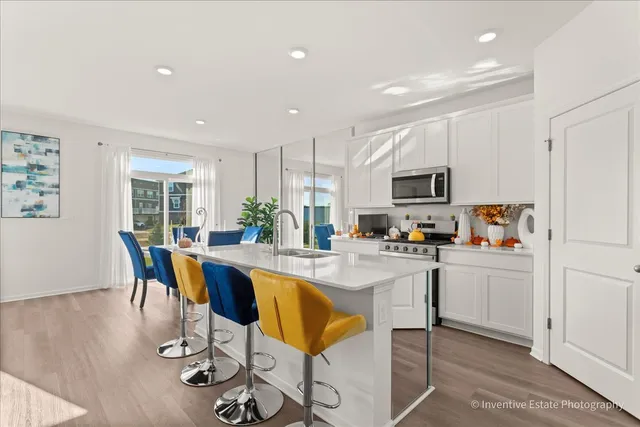 a kitchen with microwave a stove a table and chairs