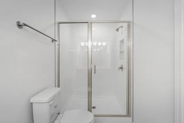 a bathroom with a shower a toilet and a sink