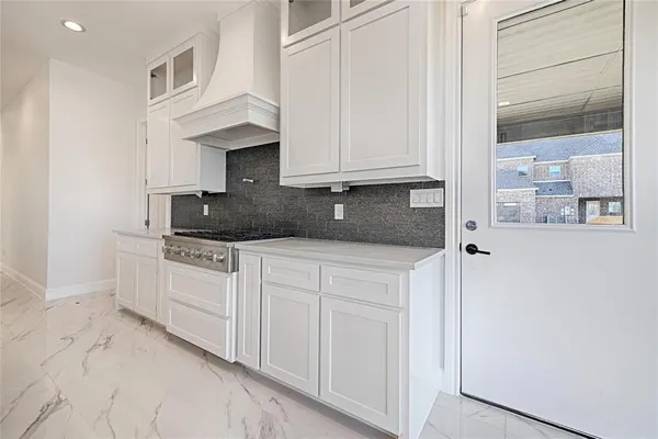 a kitchen with granite countertop white cabinets and stainless steel appliances