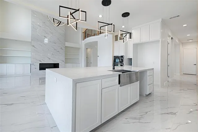 a kitchen with white cabinets and window