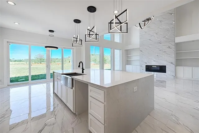 a kitchen with stainless steel appliances granite countertop a sink and a large window