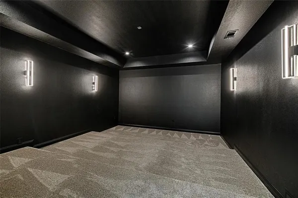 an empty room with a ceiling fan and carpet