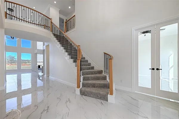 a view of staircase with lots of frames on wall and windows
