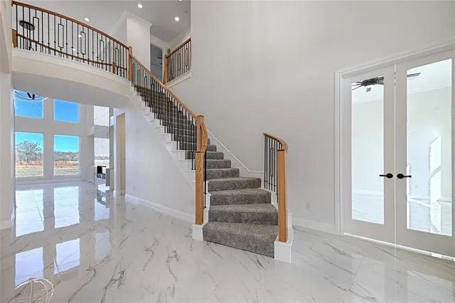 a view of staircase with lots of frames on wall and windows