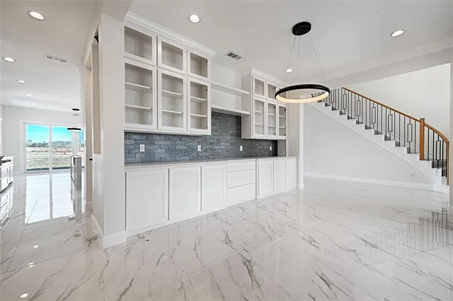 a kitchen with granite countertop a stove a sink and a refrigerator