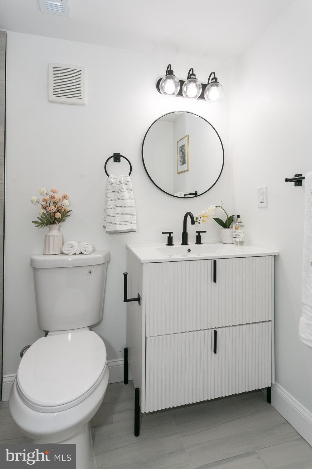 3729 Beehler Avenue Baltimore, MD 21215 - Photo 31 of 36 a bathroom with a toilet a sink and a mirror