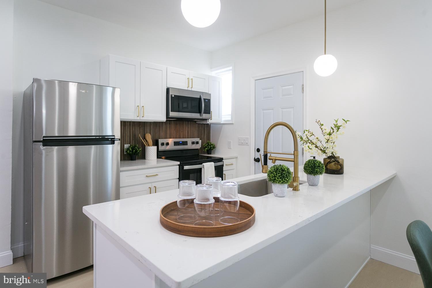 3729 Beehler Avenue Baltimore, MD 21215 - Photo 9 of 36 a kitchen with stainless steel appliances a sink a microwave a refrigerator and cabinets