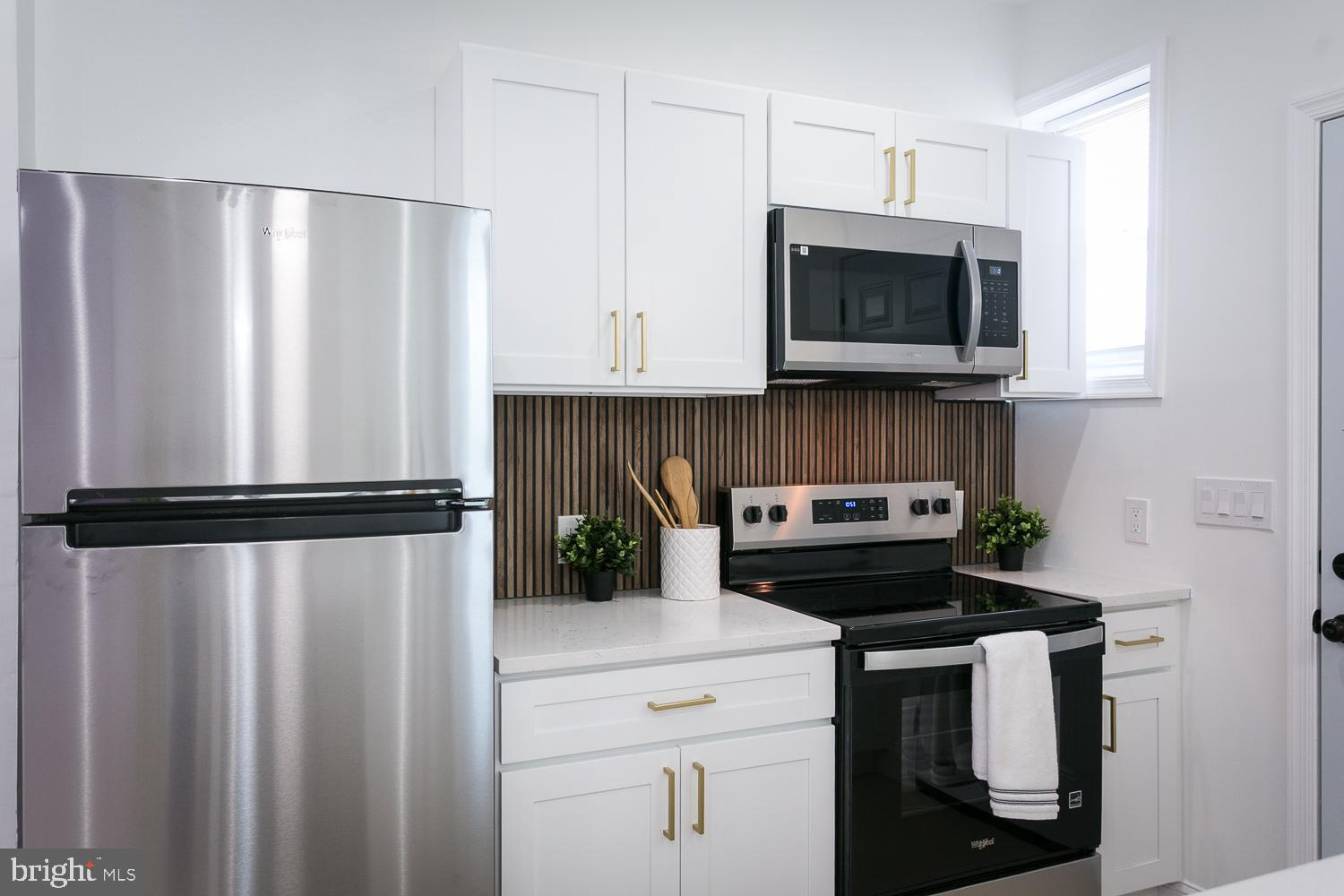 3729 Beehler Avenue Baltimore, MD 21215 - Photo 10 of 36 a kitchen with a refrigerator a microwave and cabinets