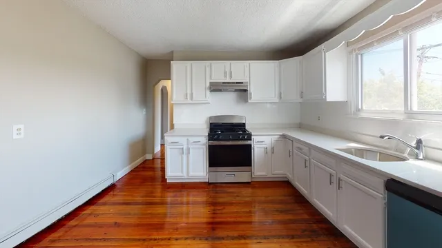 a kitchen with a sink a stove and cabinets