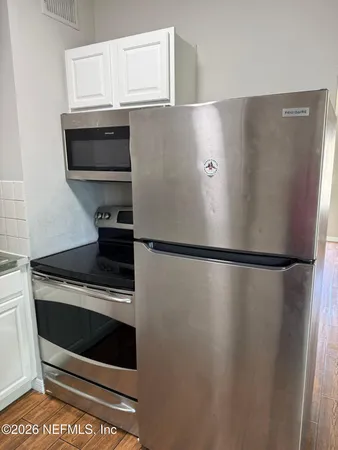 a view of stove top oven with refrigerator