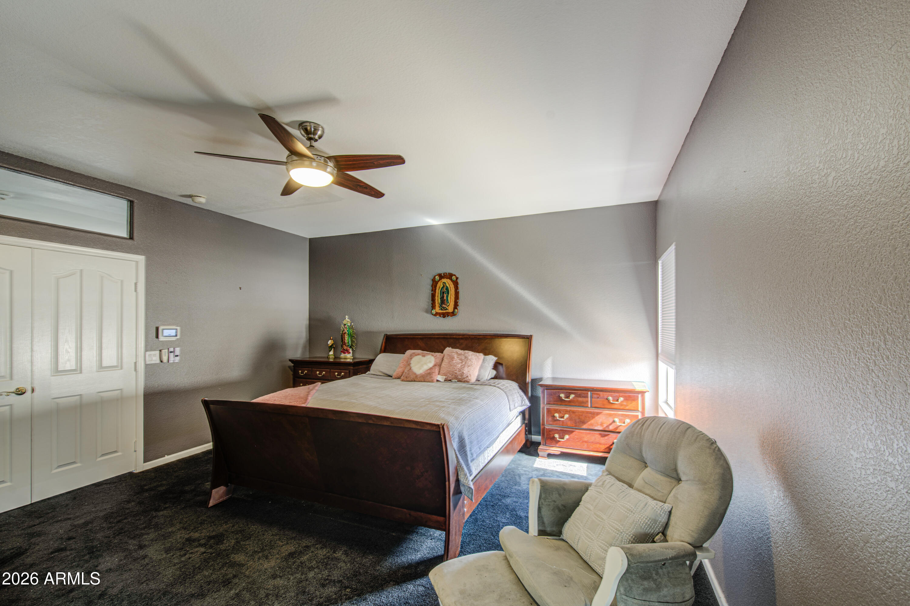 12403 West Monte Vista Road Avondale, AZ 85392 - Photo 29 of 63 a bedroom with a bed and a chandelier
