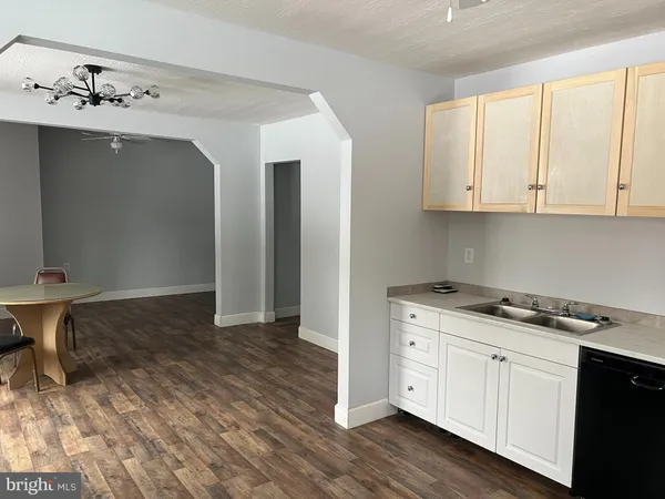 a kitchen with granite countertop a stove a sink and a wooden cabinets