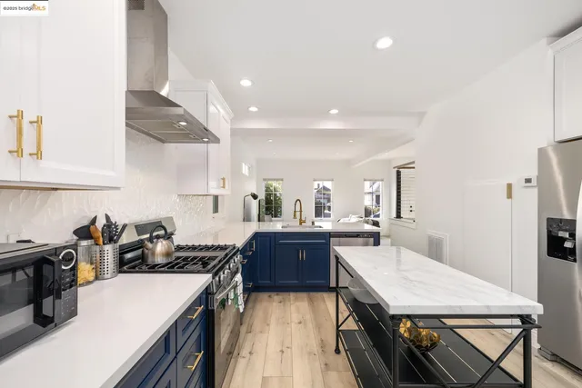 a kitchen with stainless steel appliances granite countertop sink stove and refrigerator