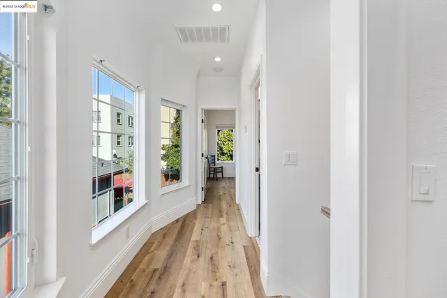 a view of a hallway with wooden floor and windows