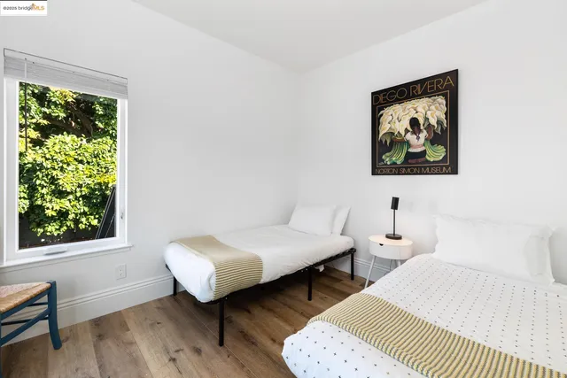 a spacious bedroom with two beds and a wooden floor