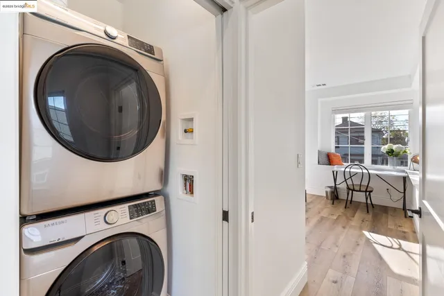 a utility room with dryer washer and a view of living room