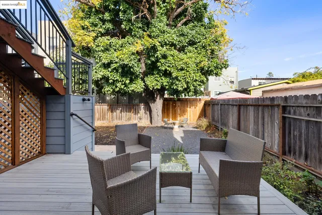 a view of backyard with outdoor seating and wooden fence