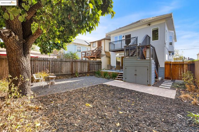 a view of a backyard with a large tree and wooden fence