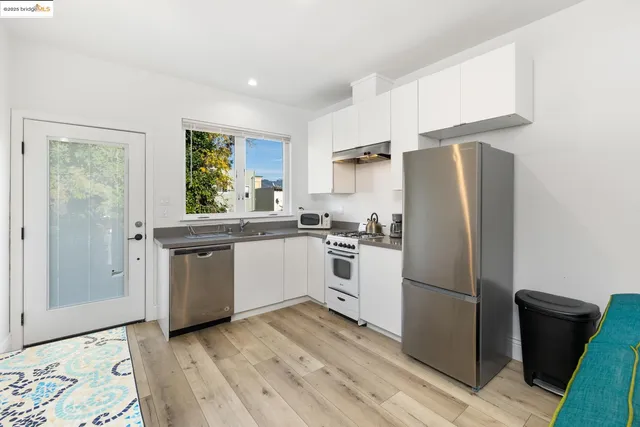 a kitchen with a refrigerator sink and cabinets