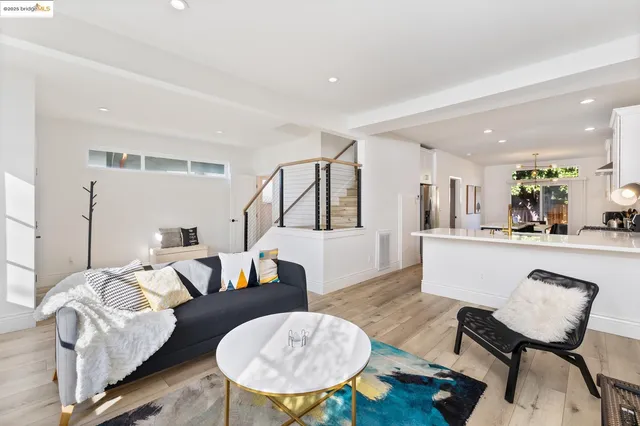 a living room with furniture and a dining table with wooden floor