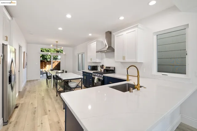 a kitchen with stainless steel appliances a table and chairs in it