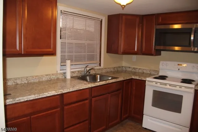 a kitchen with a sink stove top oven and cabinets