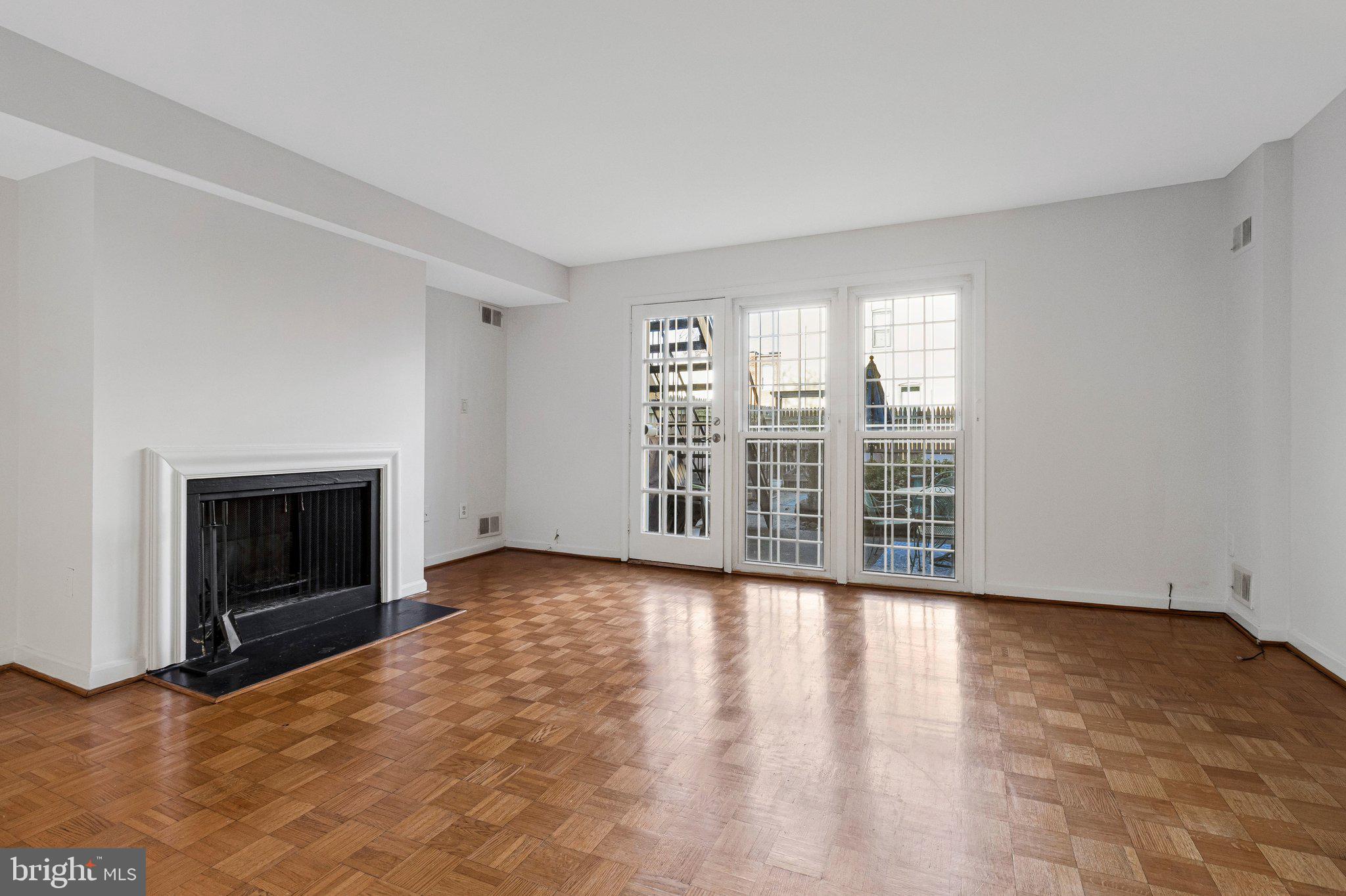 1248 C Street Southeast, Unit A Washington, DC 20003 - Photo 4 of 15 wooden floor fireplace and windows in an empty room