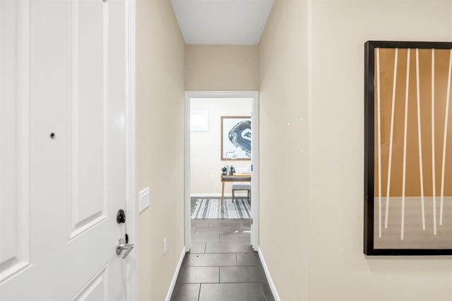 a view of a hallway with wooden floor and a cabinet