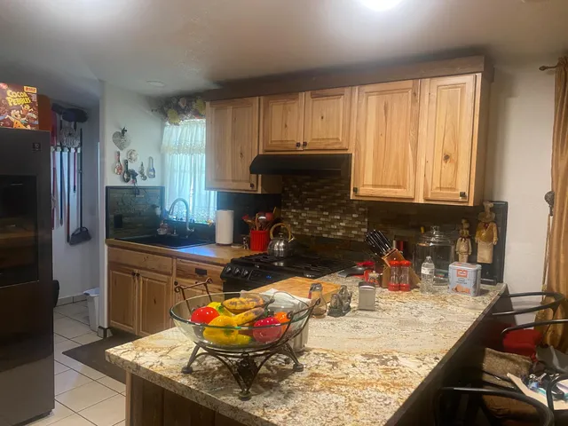 a kitchen with stainless steel appliances granite countertop a stove refrigerator and cabinets