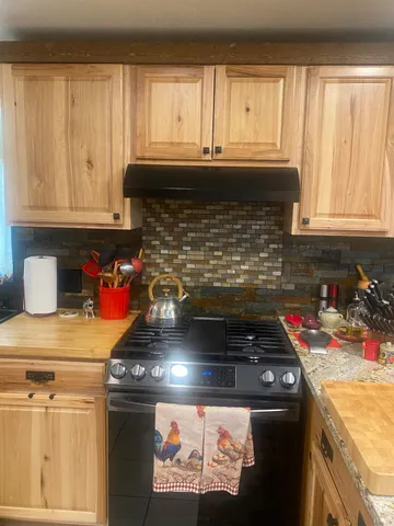 a kitchen with granite countertop a stove top oven