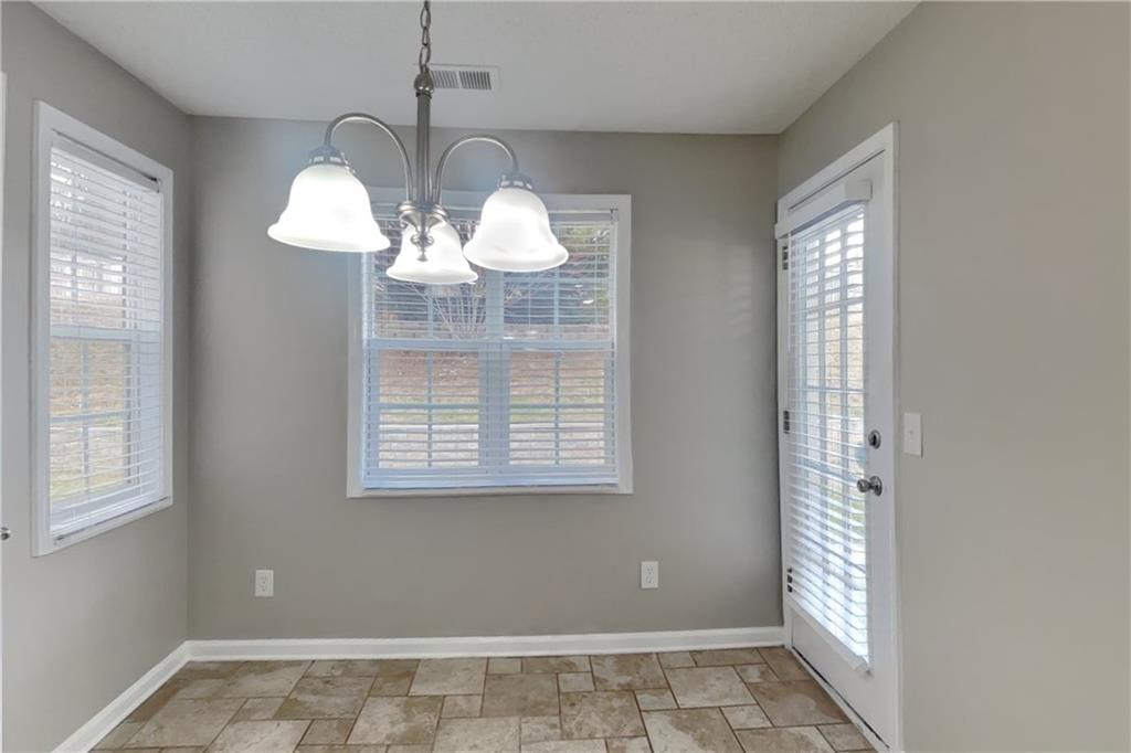 1603 Fort Perry Way Dacula, GA 30019 - Photo 5 of 19 a view of an empty room with chandelier fan and fire place