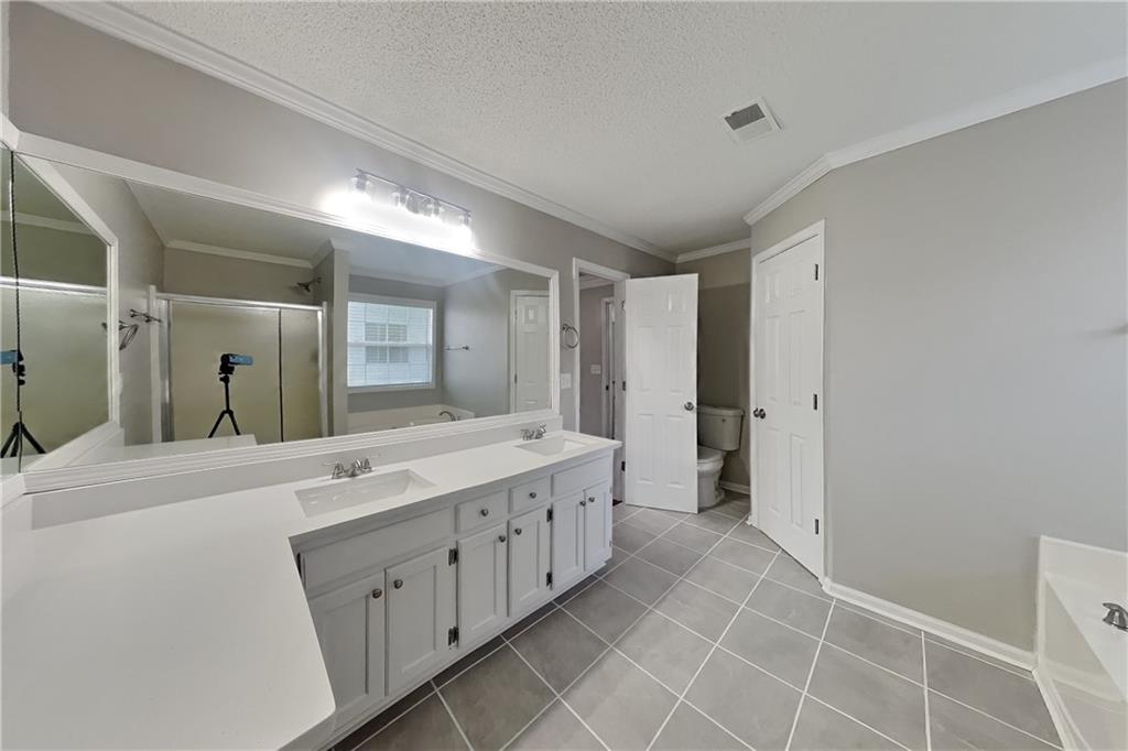 1603 Fort Perry Way Dacula, GA 30019 - Photo 9 of 19 a spacious bathroom with a double vanity sink and a mirror