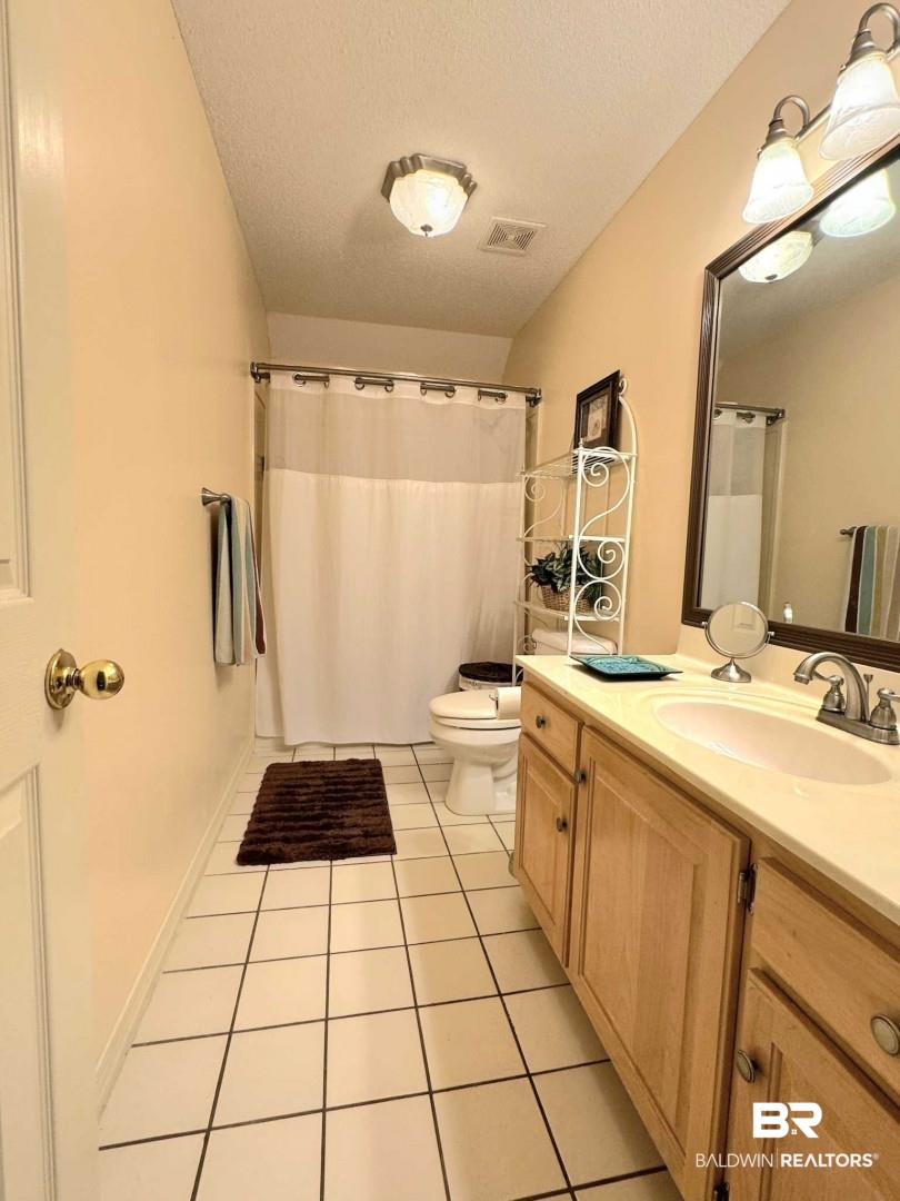 31163 Woodland Way Daphne, AL 36527 - Photo 35 of 44 Bathroom with tile patterned floors, a textured ceiling, vanity, and toilet
