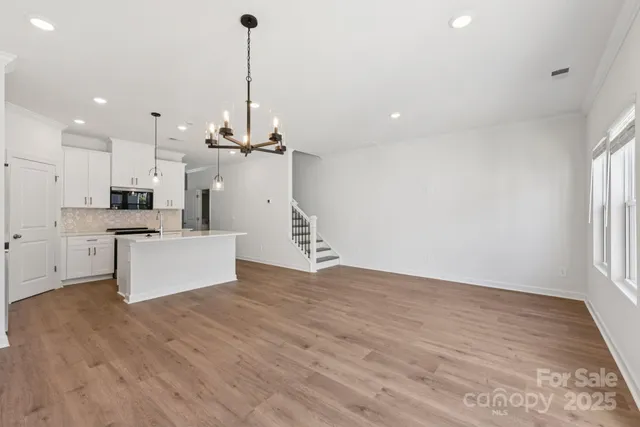 a view of a kitchen with furniture and wooden floor
